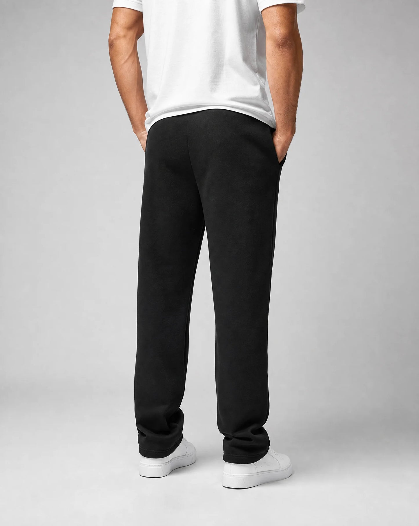 Back view of men's black relaxed fit open hem joggers featuring brushed fleece fabric and relaxed straight leg fit by ILYNORA