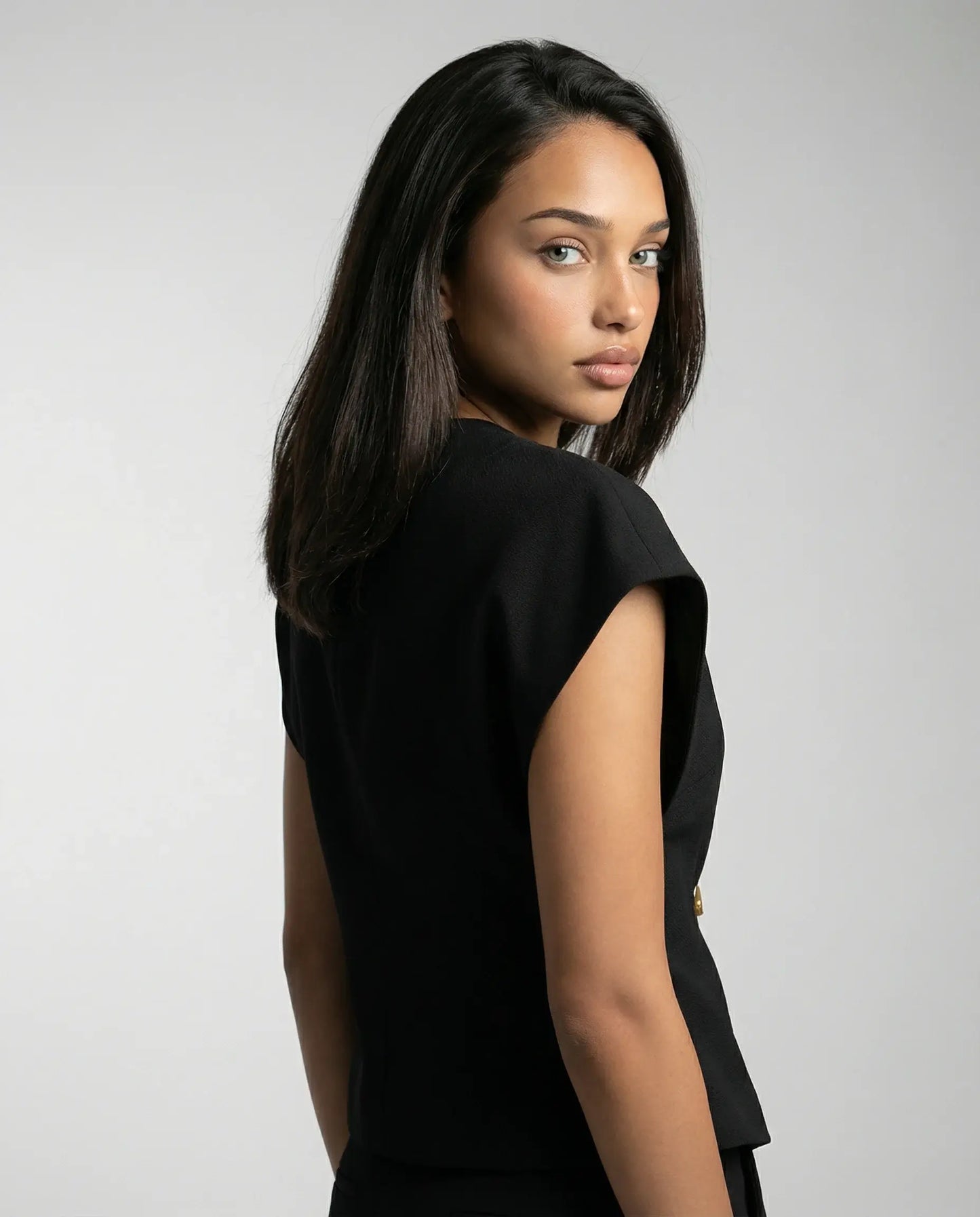 Black blouse by Ilynora, back view with soft drape and minimal design