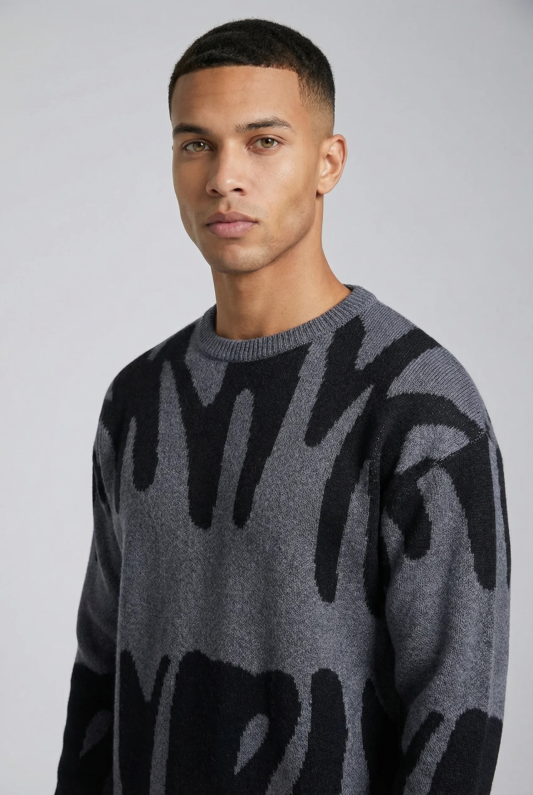 Grey abstract jacquard knit crew neck jumper for men by Ilynora London, close-up front view showing pattern details