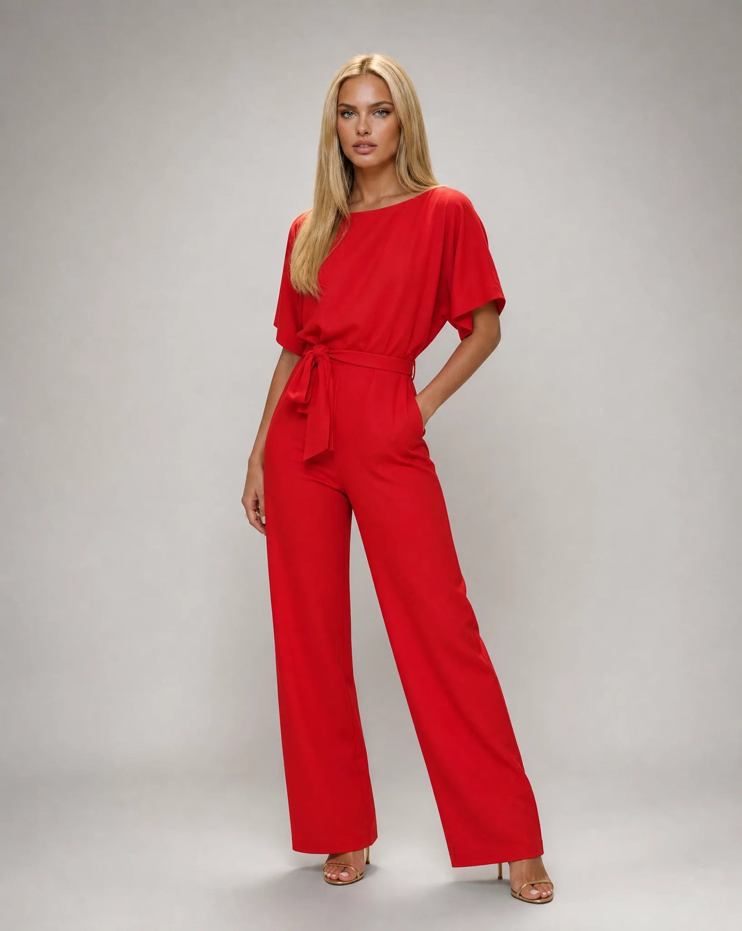Red belted wide leg jumpsuit for women by Ilynora, front view with elegant draping and flattering waist tie