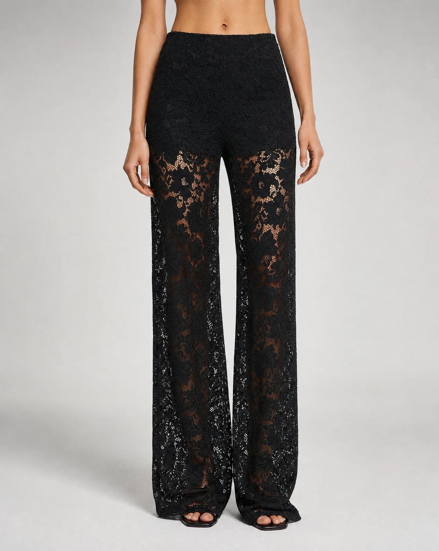 Close-up of women's black floral lace wide leg trousers with elegant sheer lace detailing and tailored finish by ILYNORA