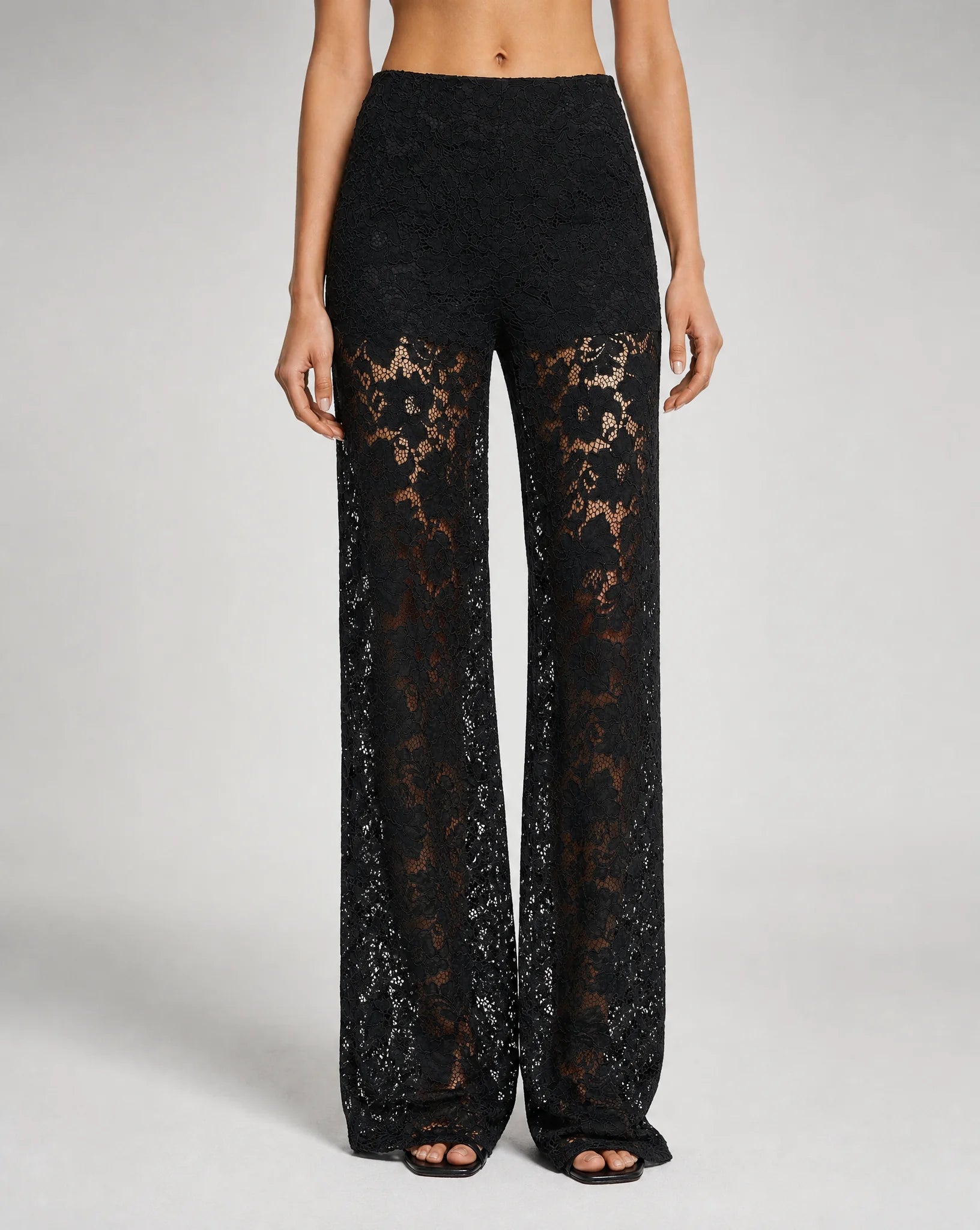Close-up of women's black floral lace wide leg trousers with elegant sheer lace detailing and tailored finish by ILYNORA