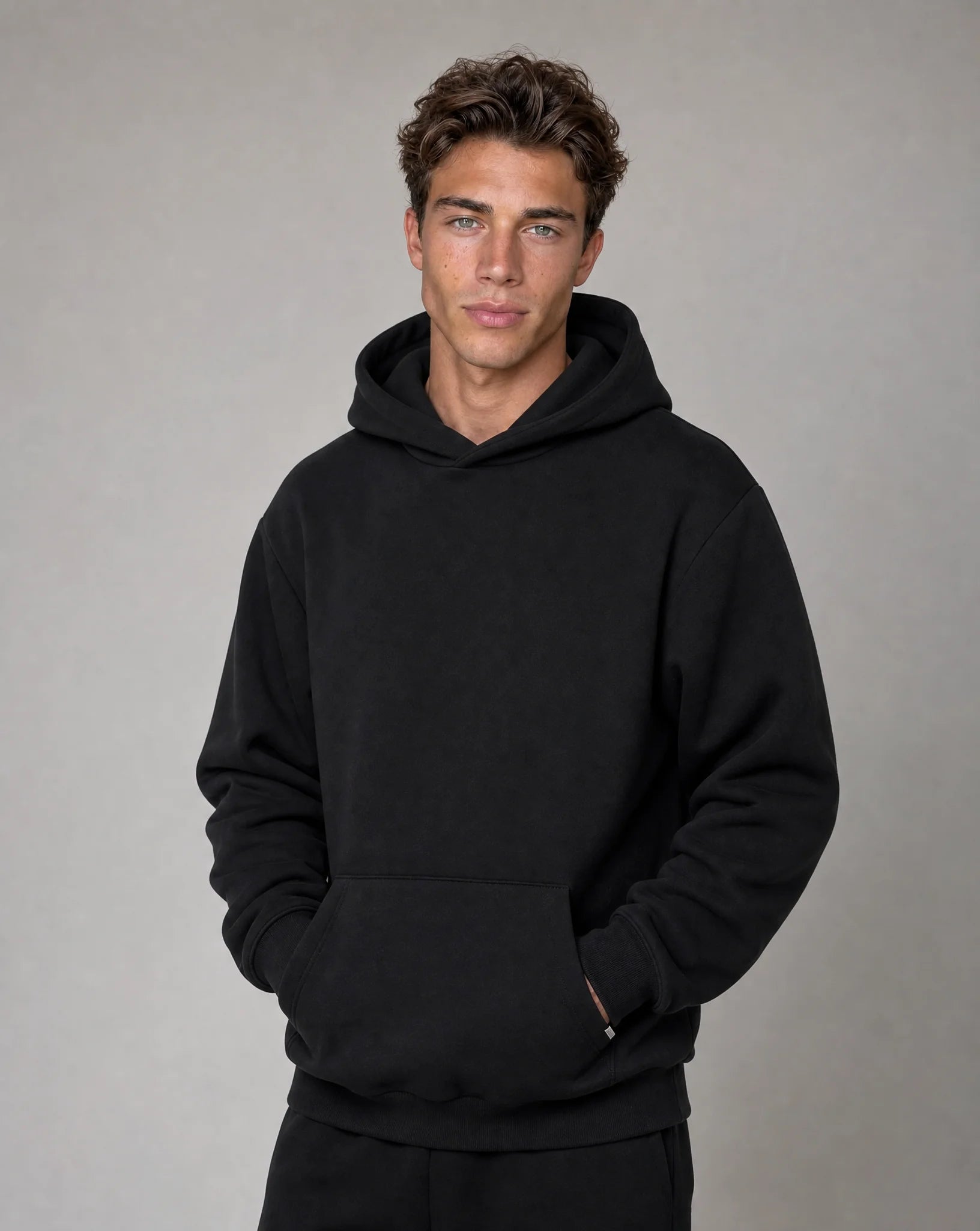 Men's black relaxed fit hoodie with brushed fleece lining, crossover hood and kangaroo pocket by ILYNORA