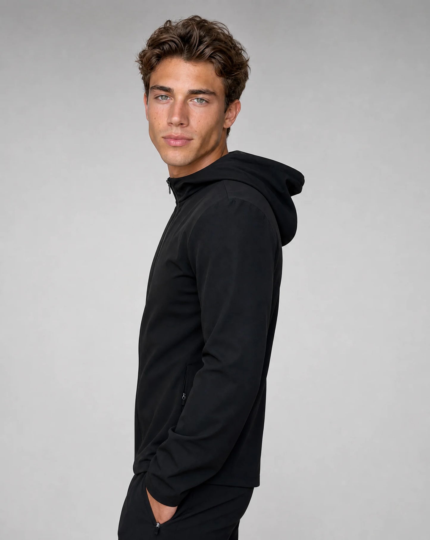 Men's black premium technical windbreaker jacket with adjustable hood, stretch fabric and modern slim fit by ILYNORA