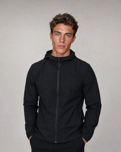 Men's black technical windbreaker jacket with hood, soft shell stretch fabric and zip pockets by ILYNORA