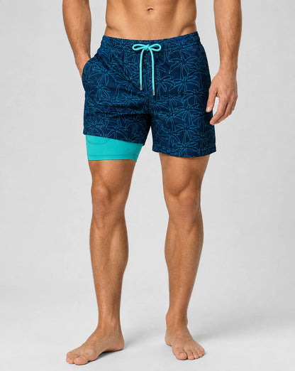 Men's sea palm swim shorts featuring compression liner and tropical leaf print by ILYNORA