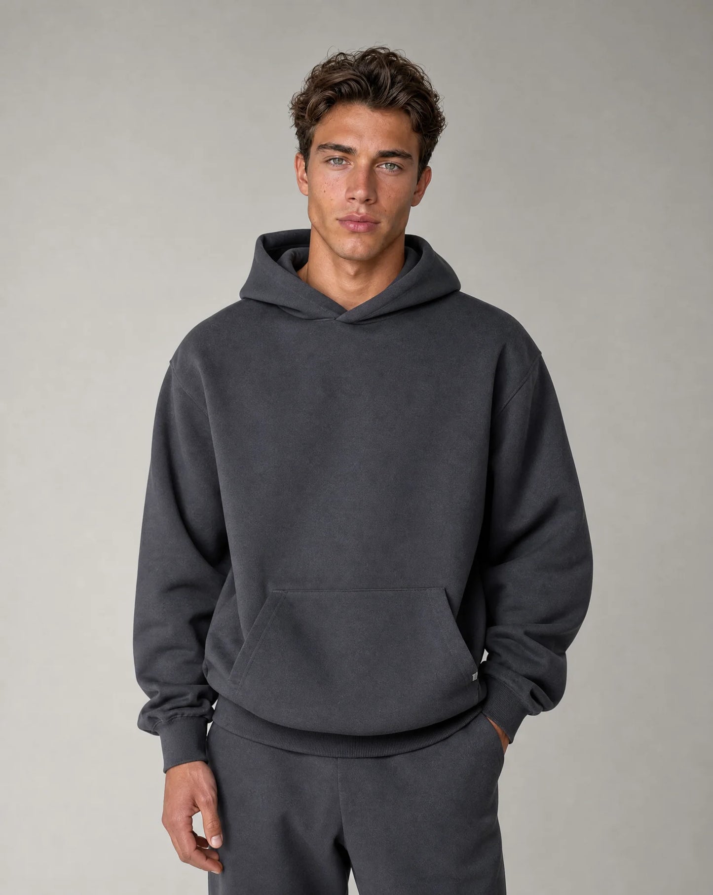 Men's dark grey relaxed fit hoodie with brushed fleece lining, crossover hood and kangaroo pocket by ILYNORA