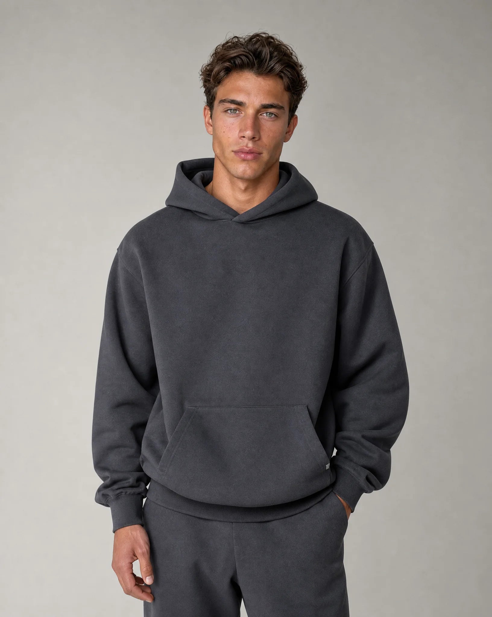 Men's dark grey relaxed fit hoodie with brushed fleece lining, crossover hood and kangaroo pocket by ILYNORA