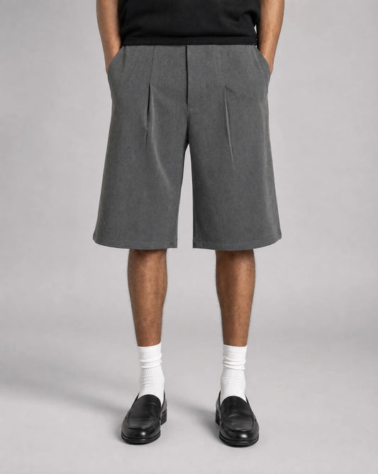 Men's grey baggy bermuda shorts with tailored front pleats, adjustable waistband and relaxed fit by ILYNORA