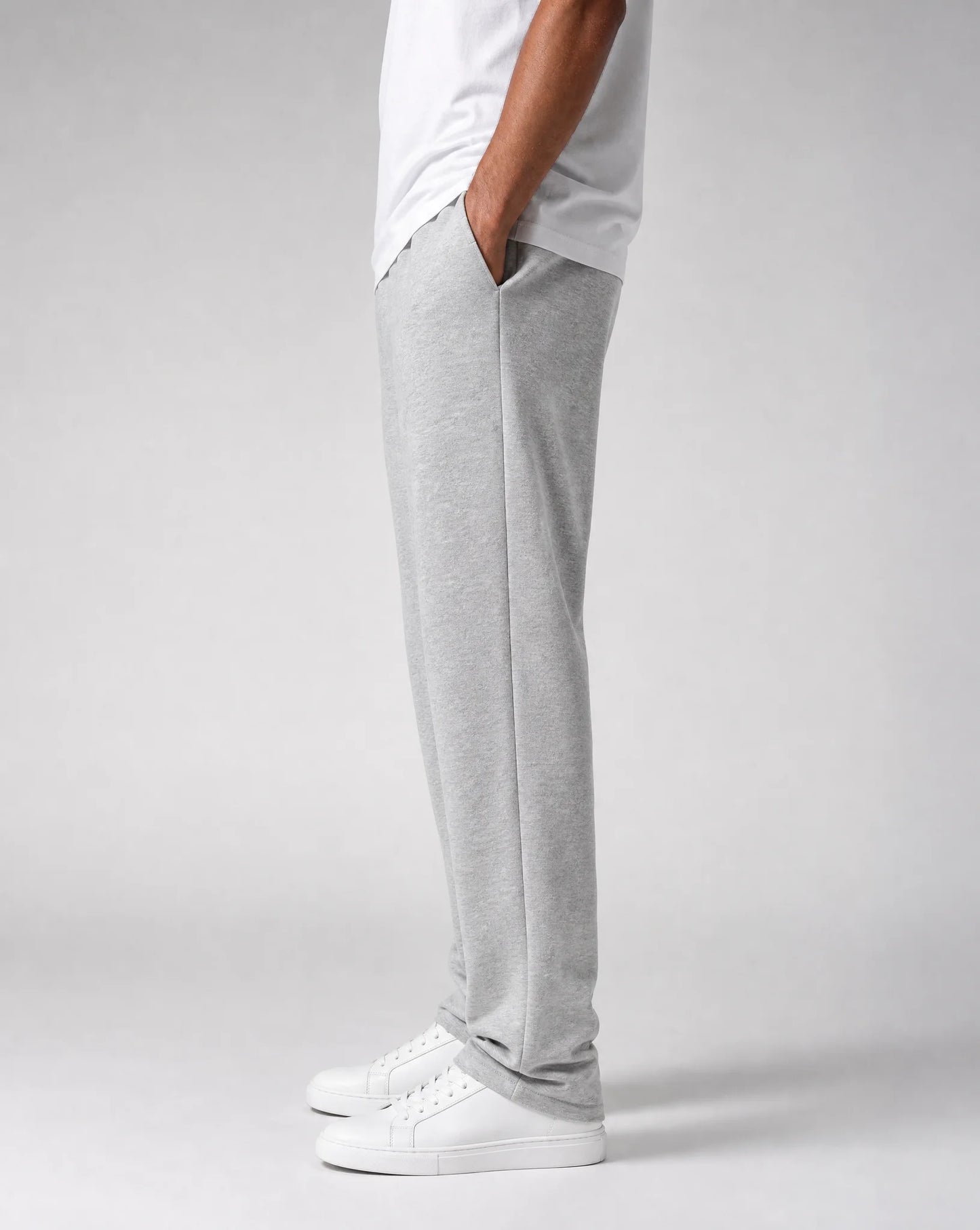 Side view of men's grey relaxed fit open hem joggers with concealed side pockets and soft brushed fleece fabric by ILYNORA