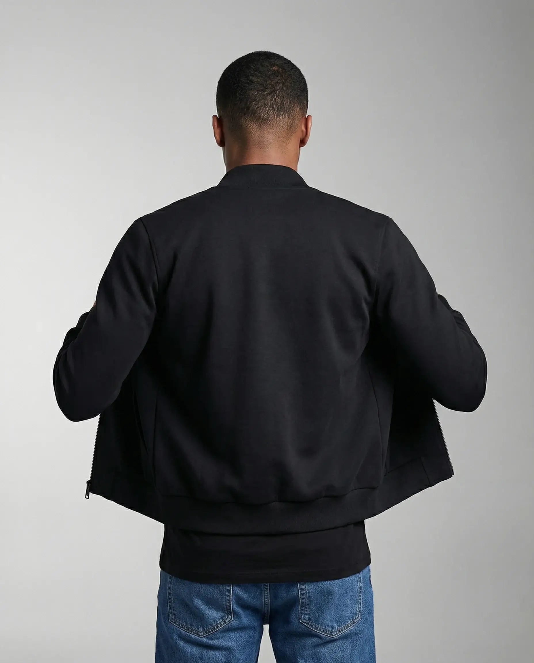 Navy blue bomber jacket by Ilynora, back view showing quilted texture and ribbed trims