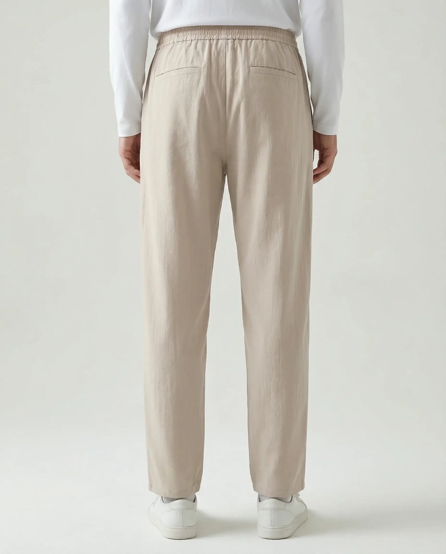 Beige linen drawstring trousers by Ilynora, full length view highlighting lightweight fabric and clean silhouette
