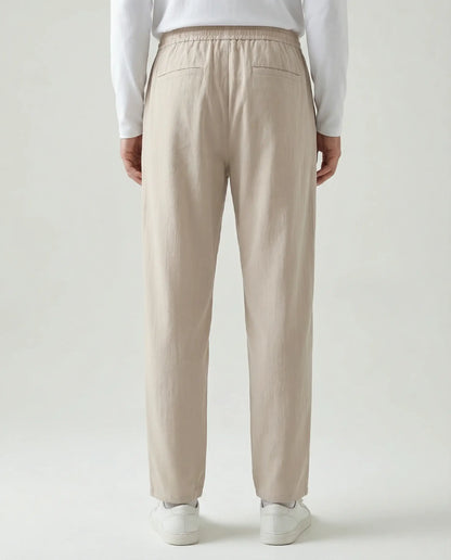 Beige linen drawstring trousers by Ilynora, full length view highlighting lightweight fabric and clean silhouette