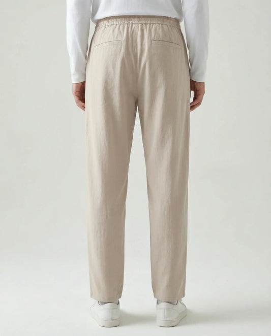 Beige linen drawstring trousers by Ilynora, full length view highlighting lightweight fabric and clean silhouette