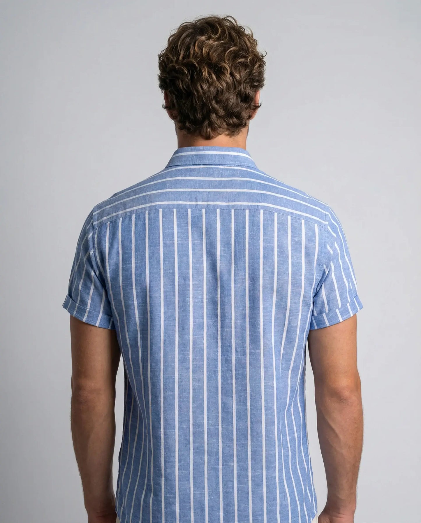 Blue striped cotton polo shirt by Ilynora, back view highlighting breathable fabric and clean silhouette
