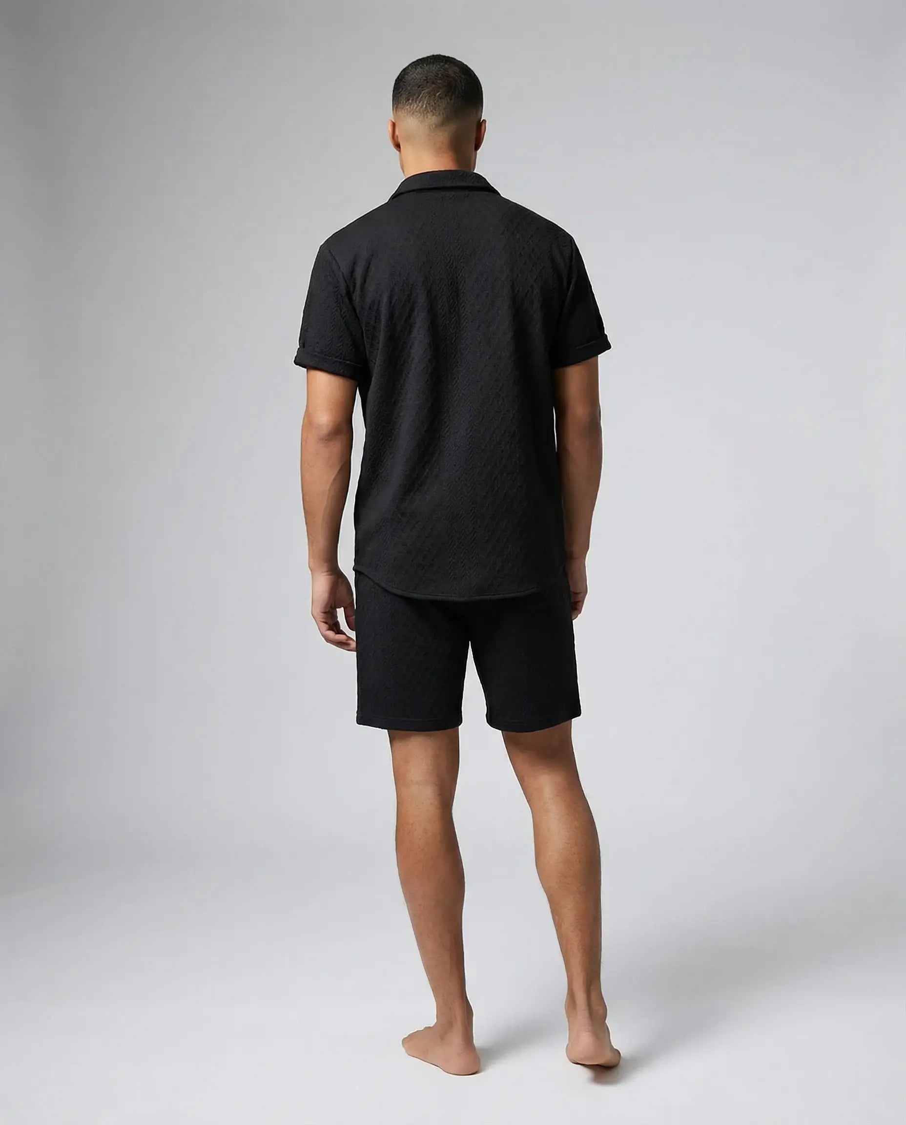 Black shirt and shorts set for men by Ilynora, back view showing relaxed summer fit and minimal design