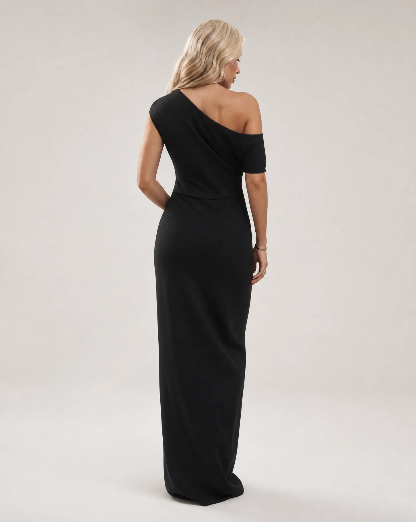 Black one shoulder maxi dress for women by Ilynora, back view showcasing the elegant drape and modern silhouette