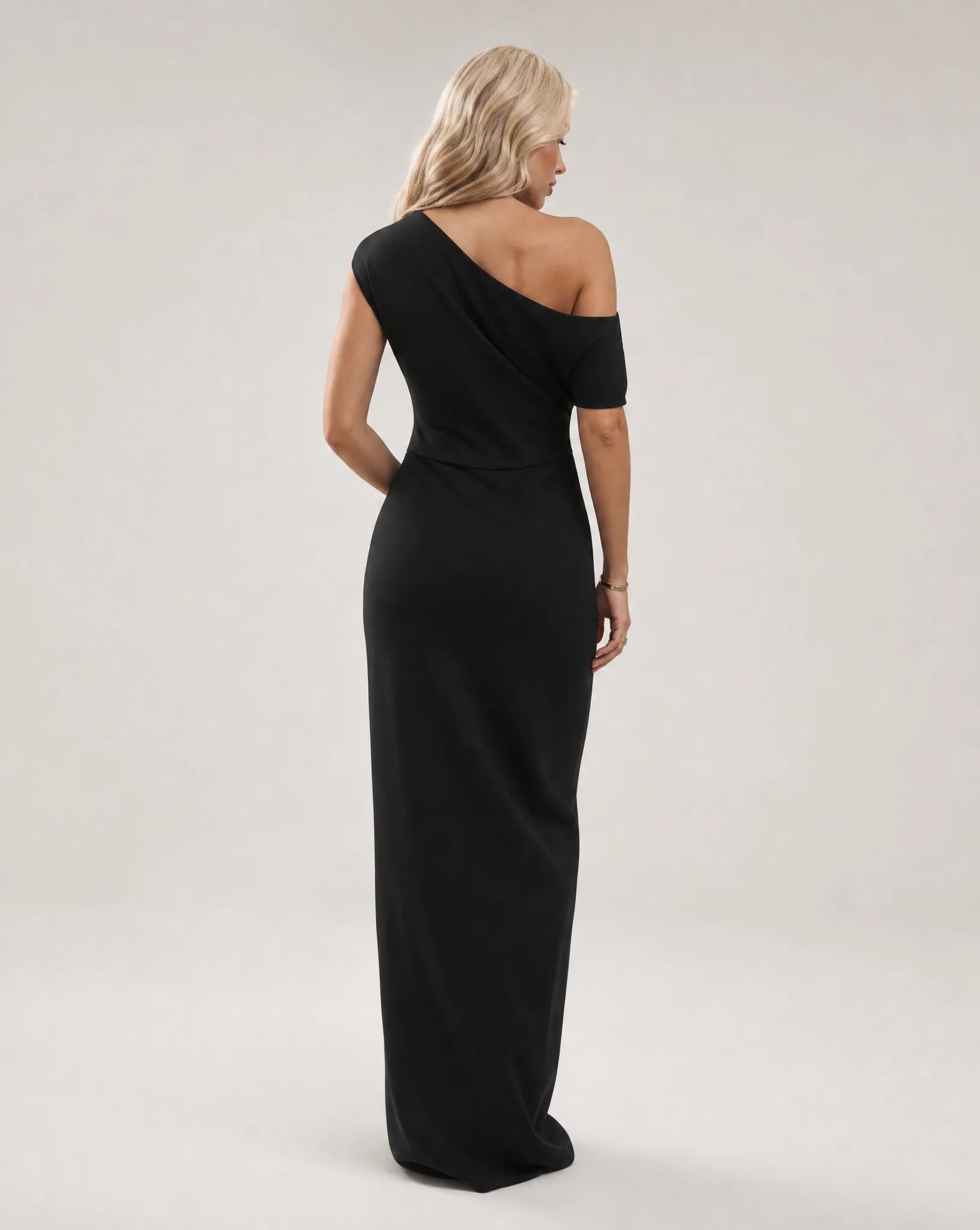 Black one shoulder maxi dress for women by Ilynora, back view showcasing the elegant drape and modern silhouette