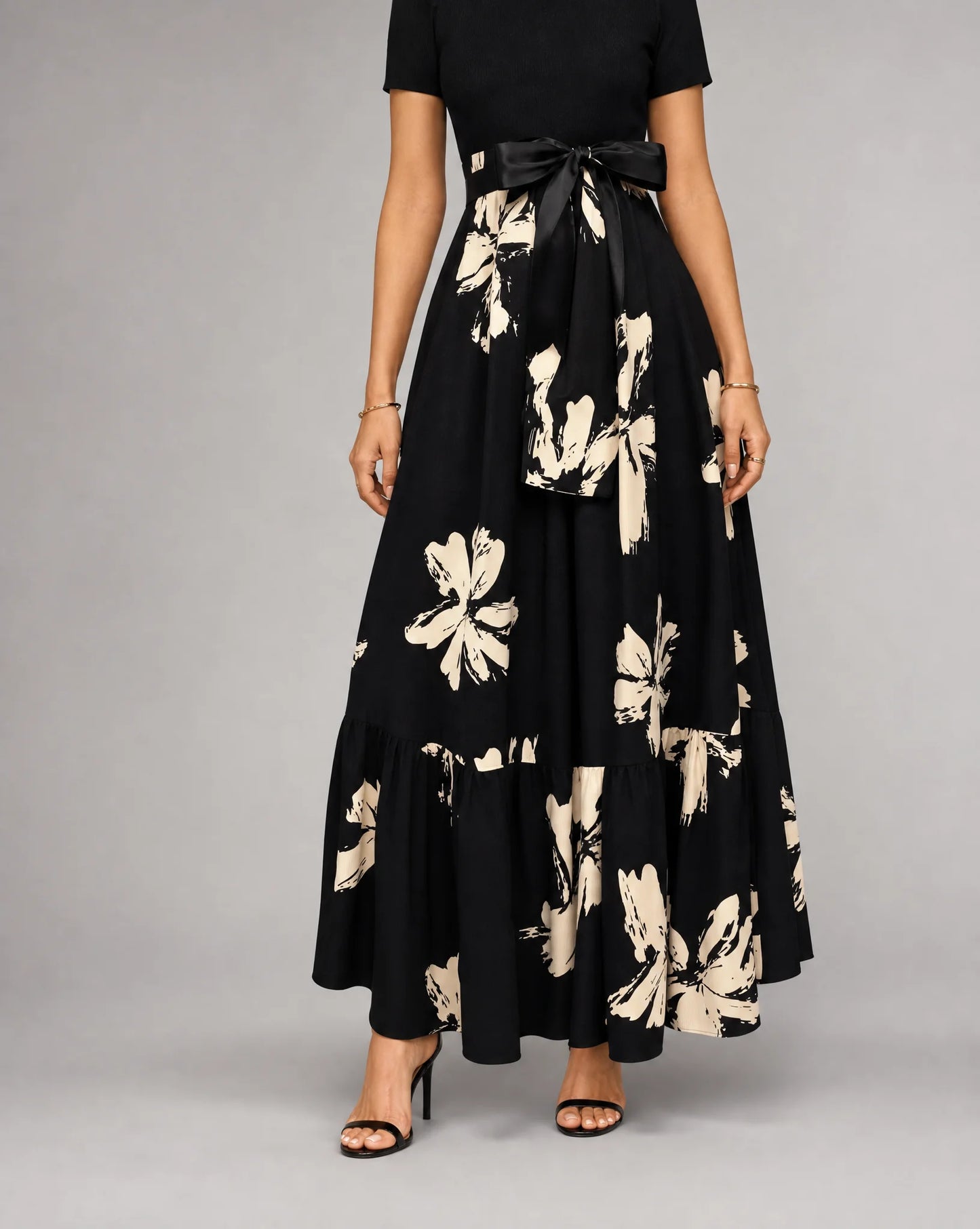 Black printed A line midaxi dress for women by Ilynora, front view with flowing skirt and floral print