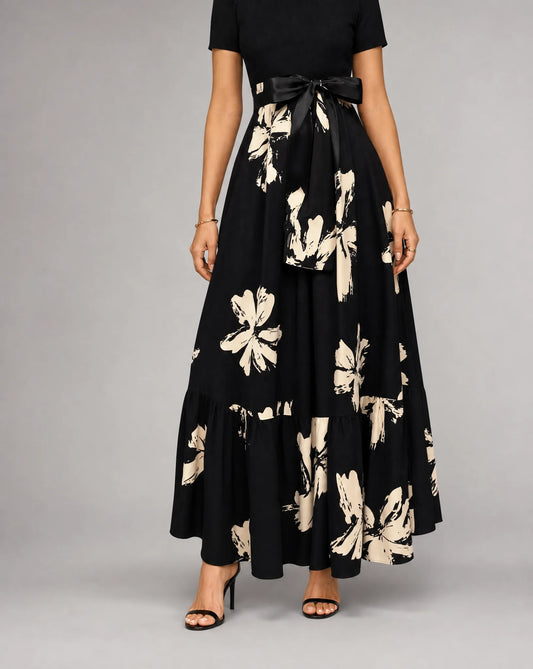 Black printed A line midaxi dress for women by Ilynora, front view with flowing skirt and floral print