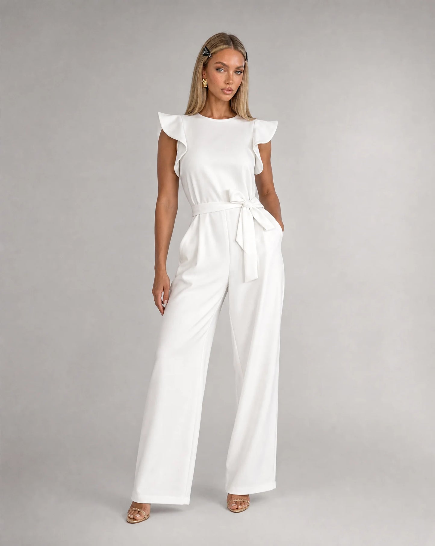 White ruffle sleeve jumpsuit for women by Ilynora, front view with belted waist and flowing silhouette