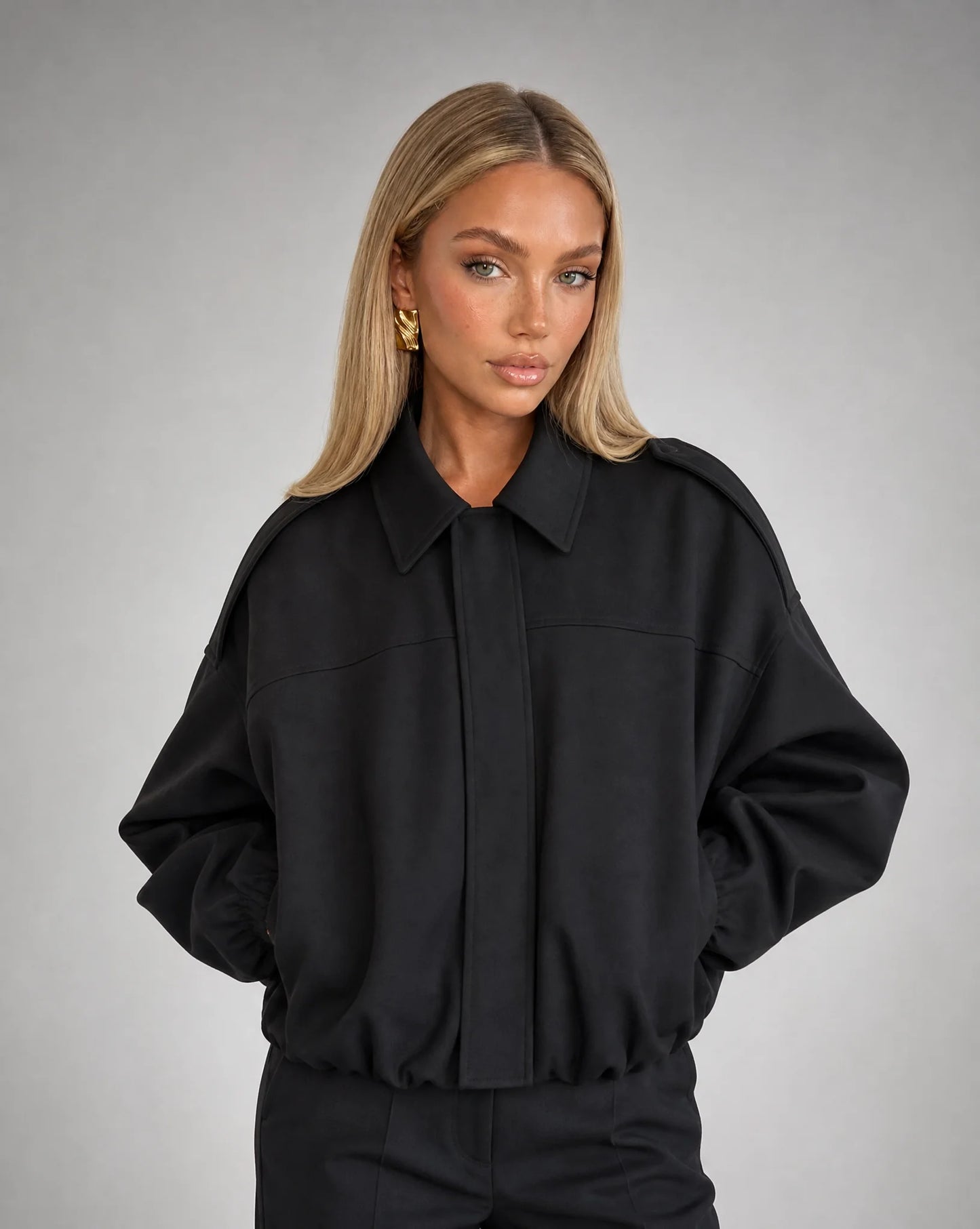 Black suede bomber jacket for women by Ilynora, front view with oversized fit and minimalist style