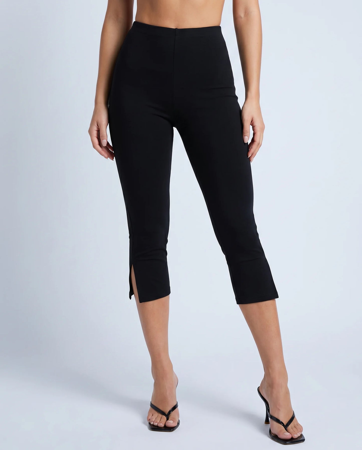 Women's black split hem capri leggings with slim stretch fit and cropped length by ILYNORA