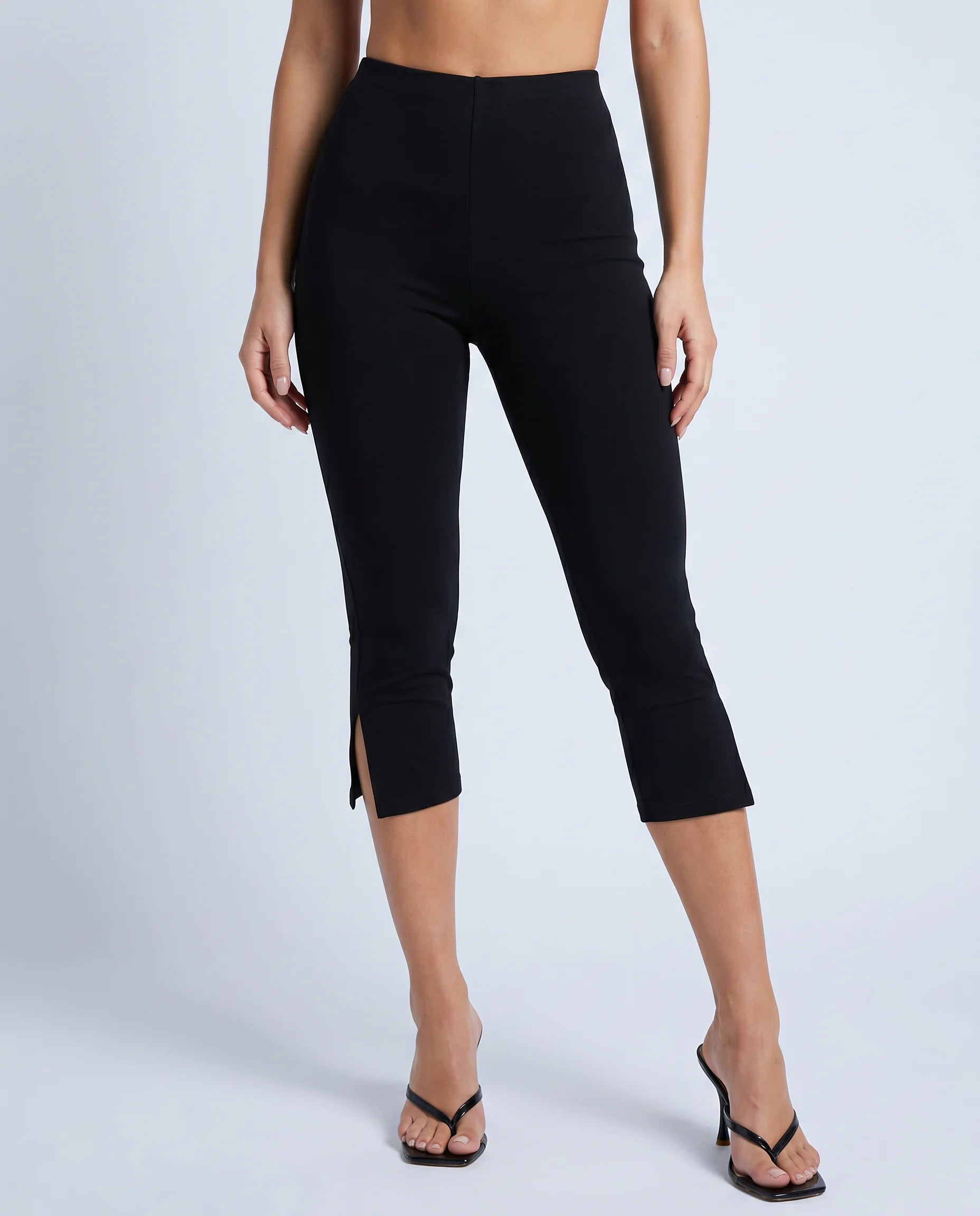 Women's black split hem capri leggings with slim stretch fit and cropped length by ILYNORA