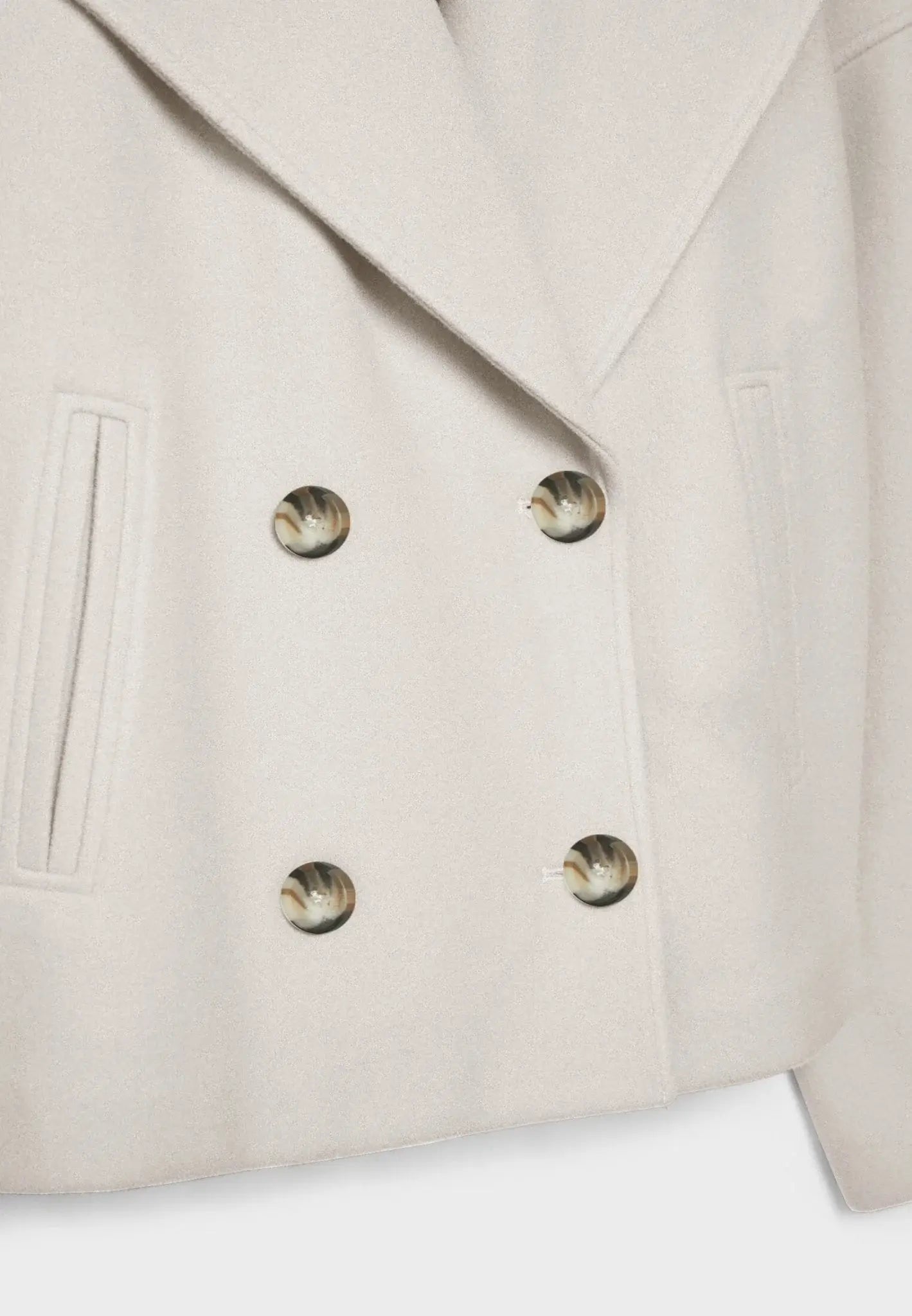 White cropped jacket by Ilynora, angled view with sharp lapels and contemporary fit