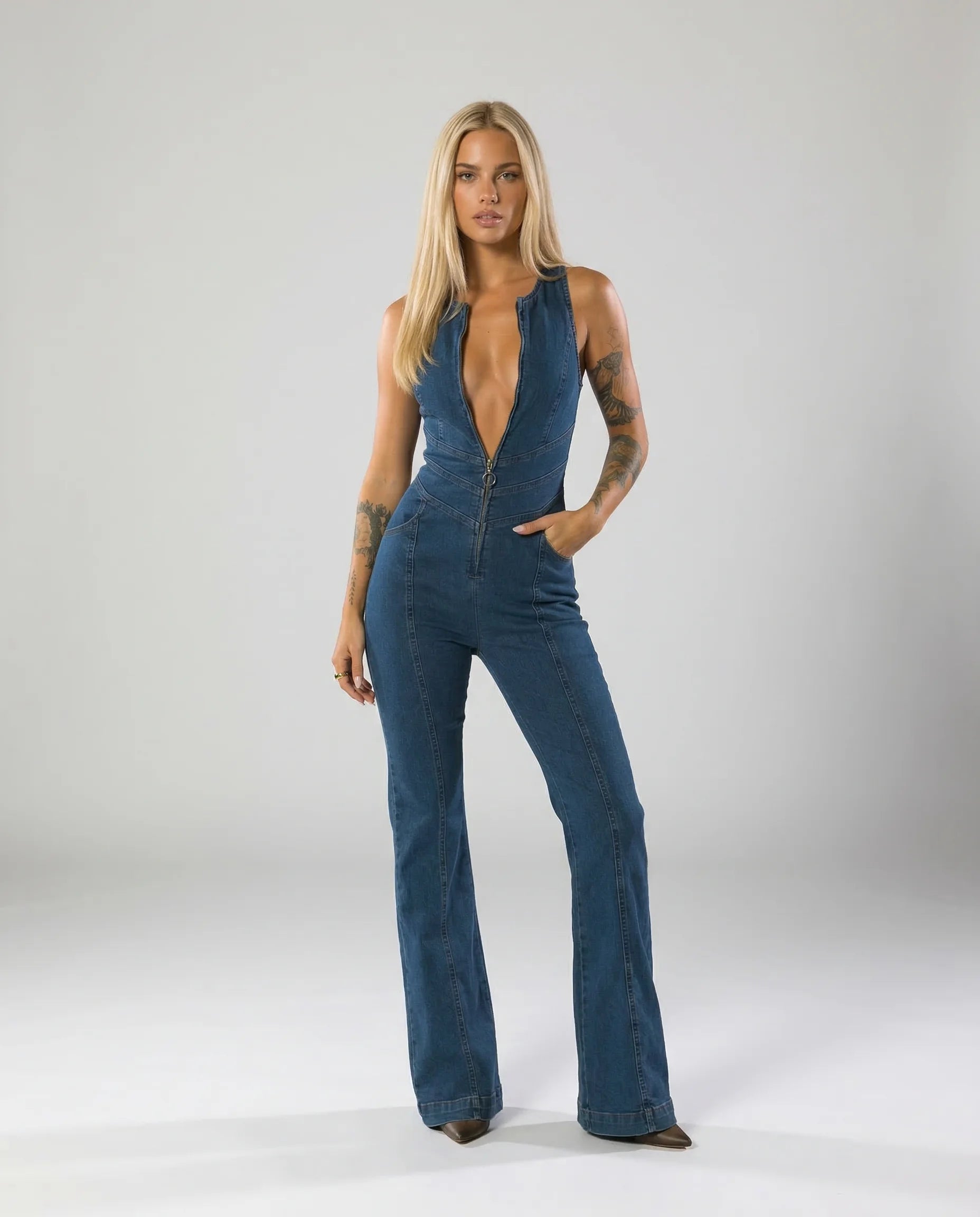 Women's deep V denim flare jumpsuit by Ilynora, front view with plunging neckline and fitted silhouette