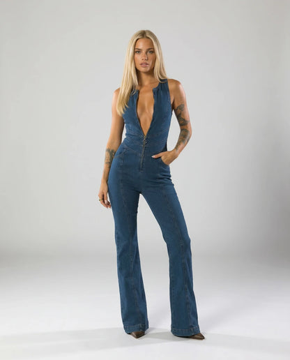 Women's deep V denim flare jumpsuit by Ilynora, front view with plunging neckline and fitted silhouette