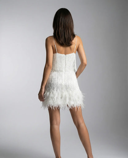 White fringe mini dress by Ilynora, back view highlighting feather trim and elegant silhouette