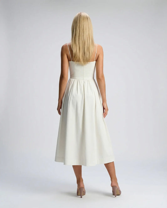 White flowy midi dress by Ilynora, back view with soft drape and minimal silhouette