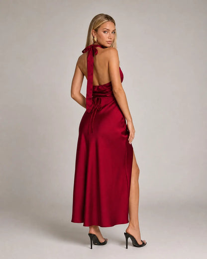 Red halterneck satin maxi dress for women by Ilynora, full length view highlighting the fluid fit and leg split