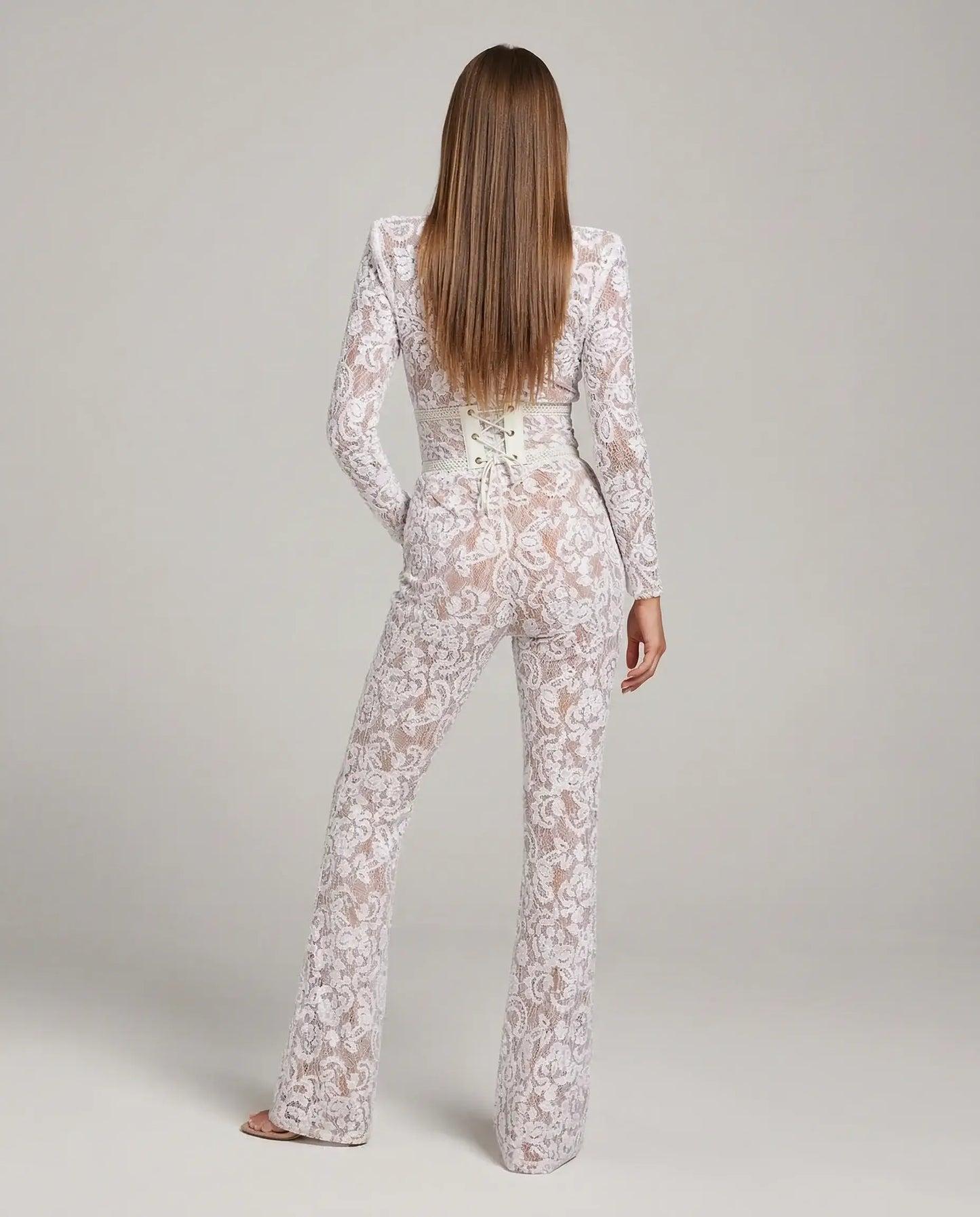 White lace flare jumpsuit by Ilynora, back view highlighting sculpted waist and elegant silhouette