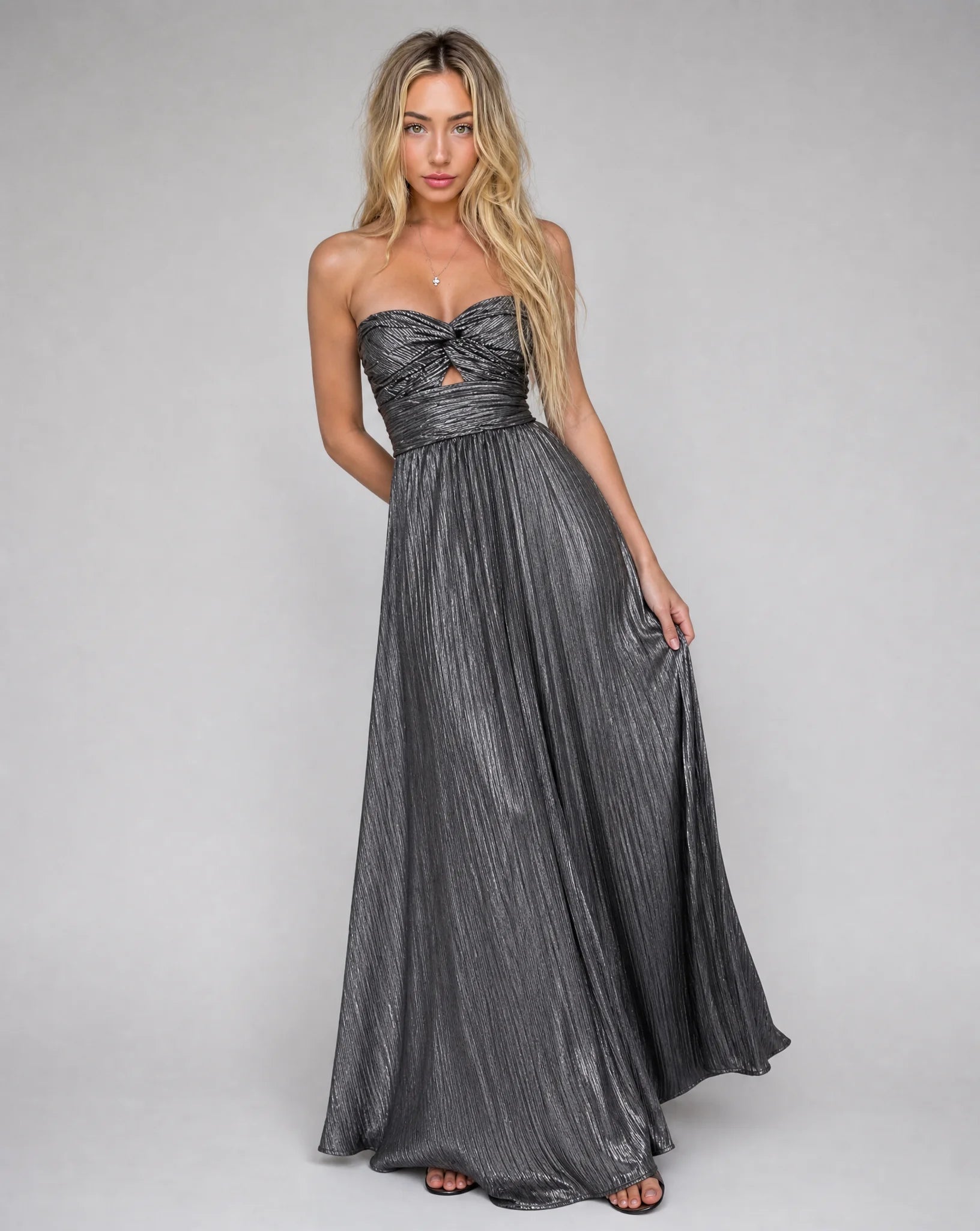 Black metallic pleated maxi dress with fitted waist and floor length pleated skirt by ILYNORA