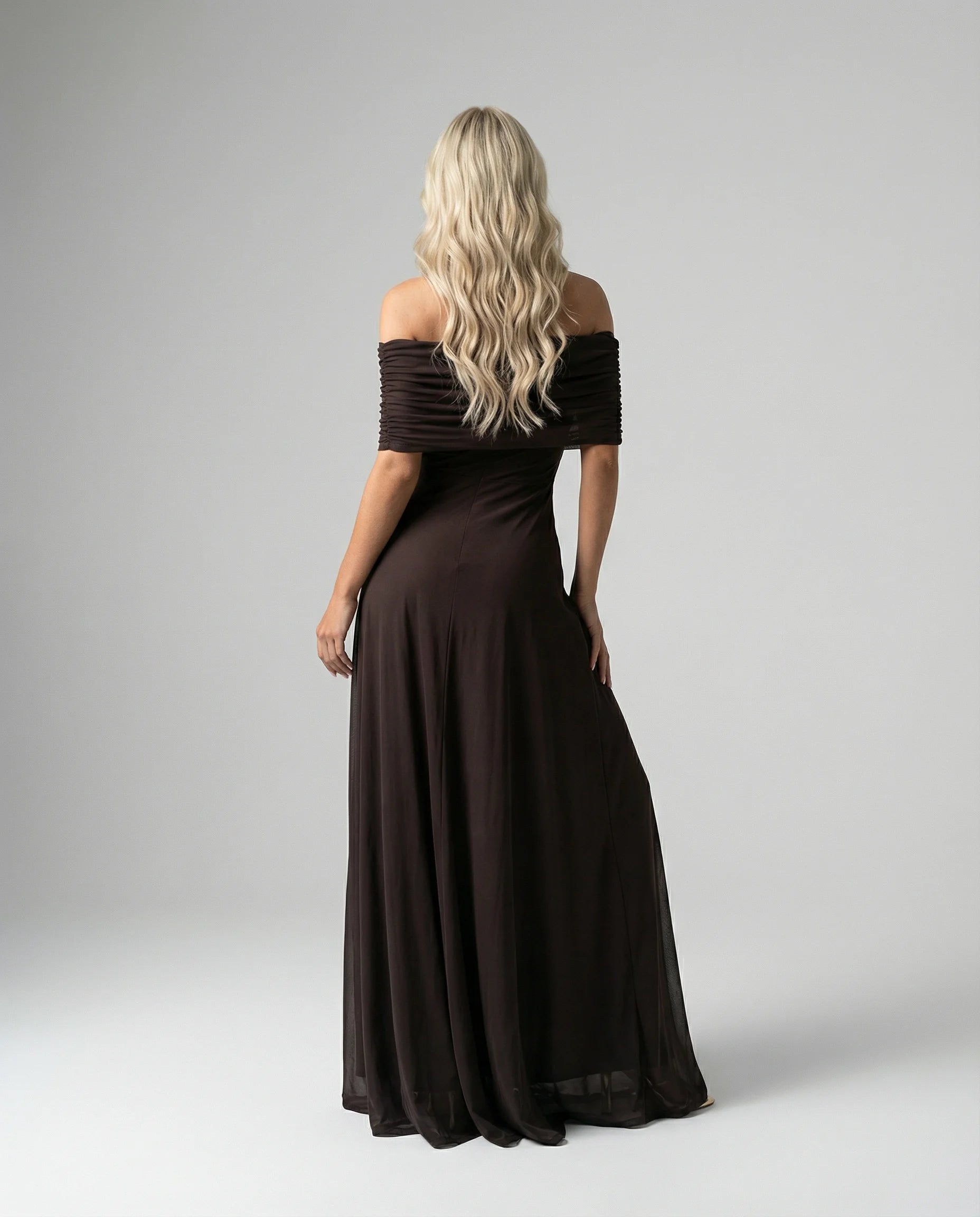 Black off-shoulder sheer maxi dress for women by Ilynora, angled view showing flowing fabric and feminine fit