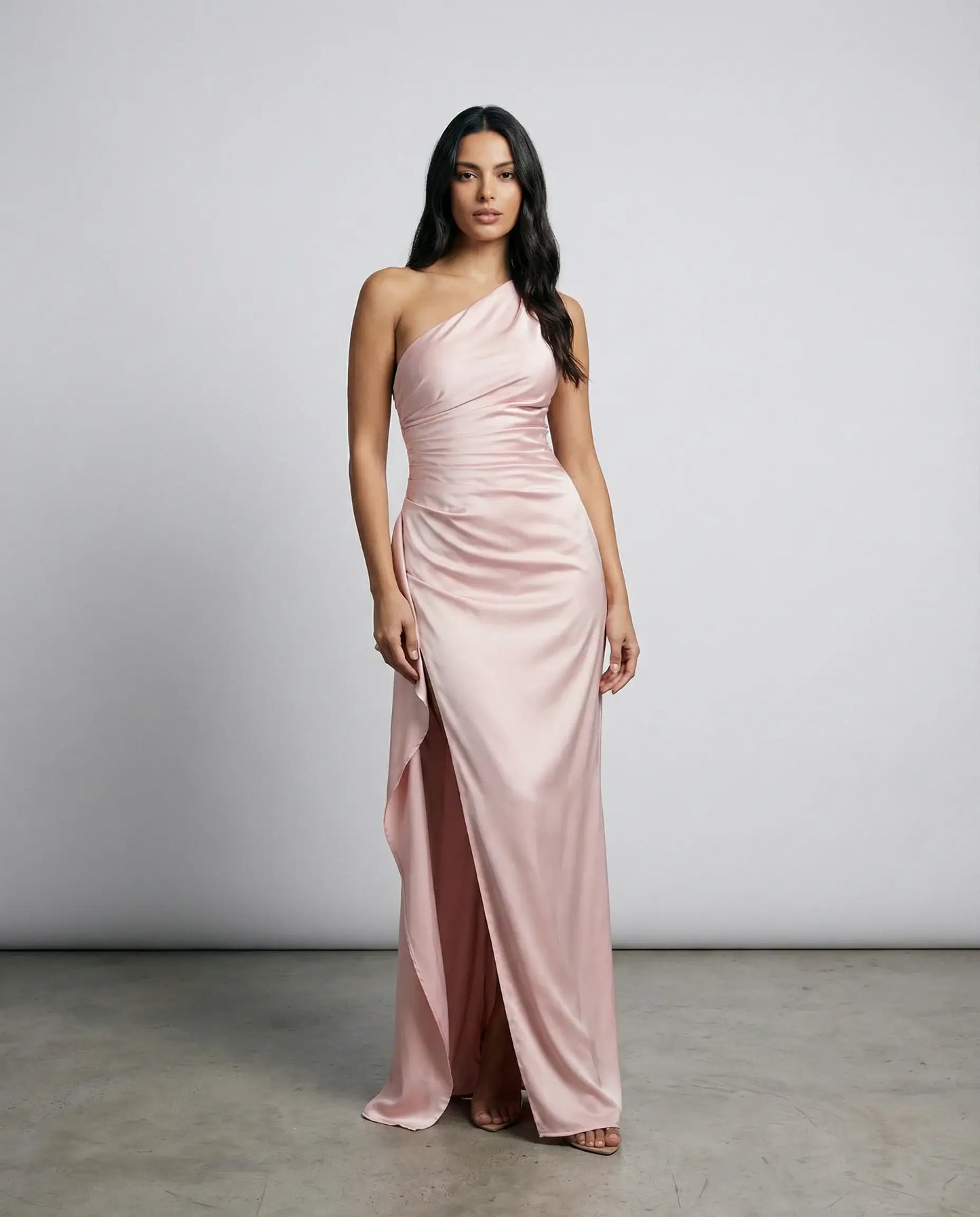 Women's one-shoulder satin maxi dress in pink by Ilynora, front view with ruched waist and flowing satin fabric