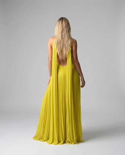 Back view of a yellow pleated halter maxi dress with open back and floor length silhouette