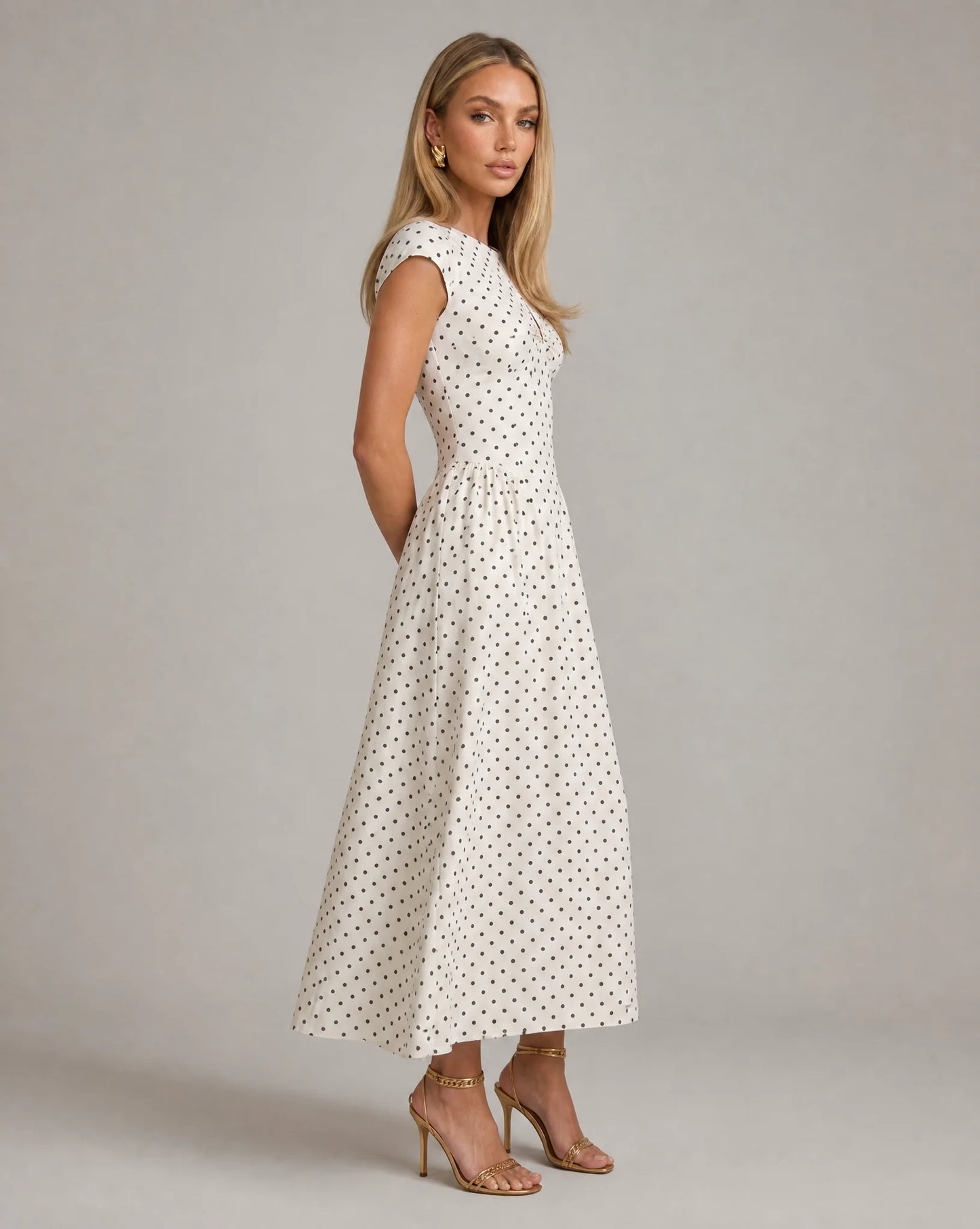 White polka dot fit and flare midi dress side view with fitted bodice and timeless occasion wear by ILYNORA