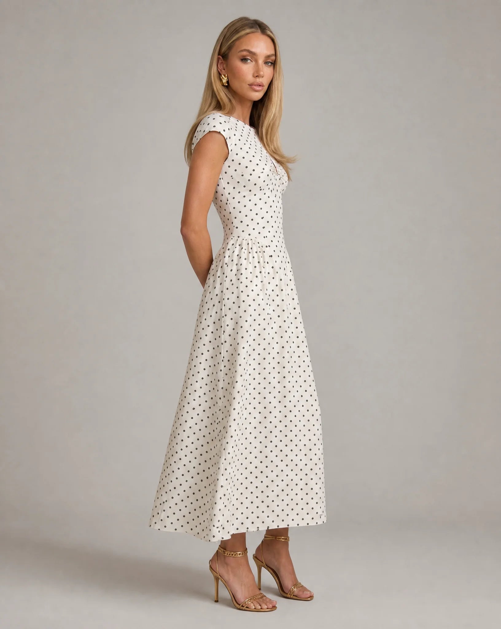 White polka dot fit and flare midi dress side view with fitted bodice and timeless occasion wear by ILYNORA