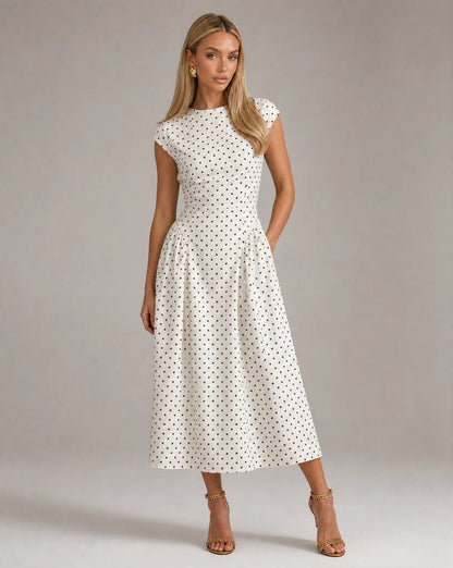 White polka dot fit and flare midi dress with cap sleeves and elegant wedding guest styling by ILYNORA