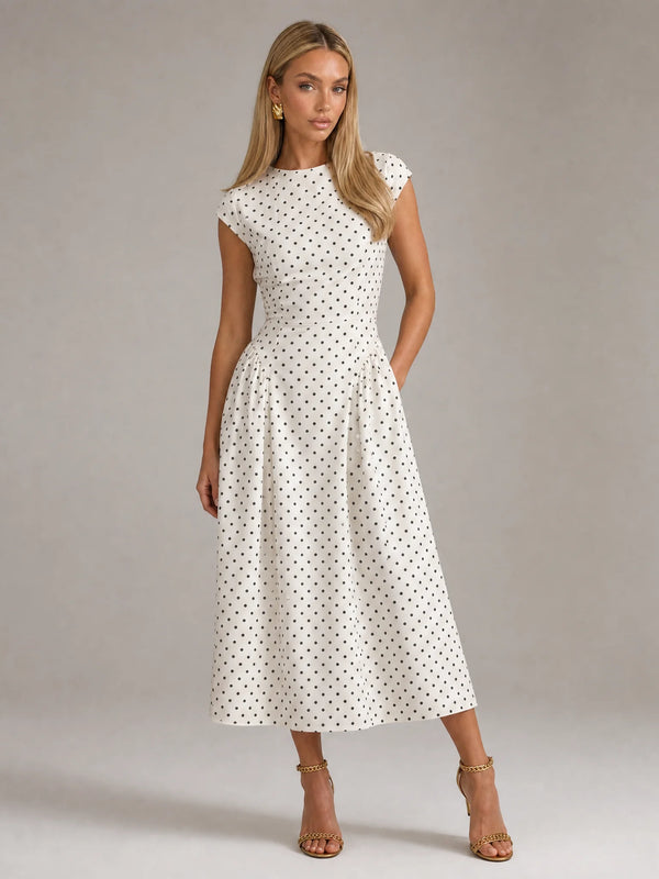White polka dot fit and flare midi dress with cap sleeves and elegant wedding guest styling by ILYNORA
