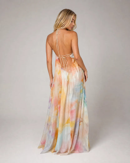 Orange printed halter maxi dress back view with open back design and flowing skirt by ILYNORA