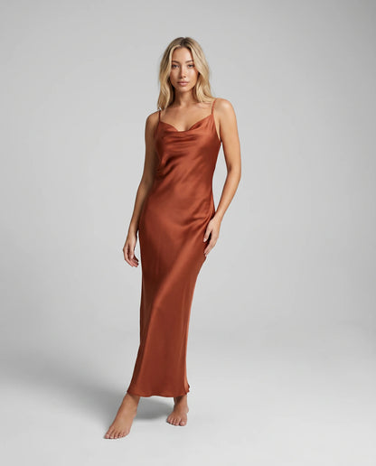 Brown satin cowl neck maxi dress with elegant open back and floor length silhouette by ILYNORA