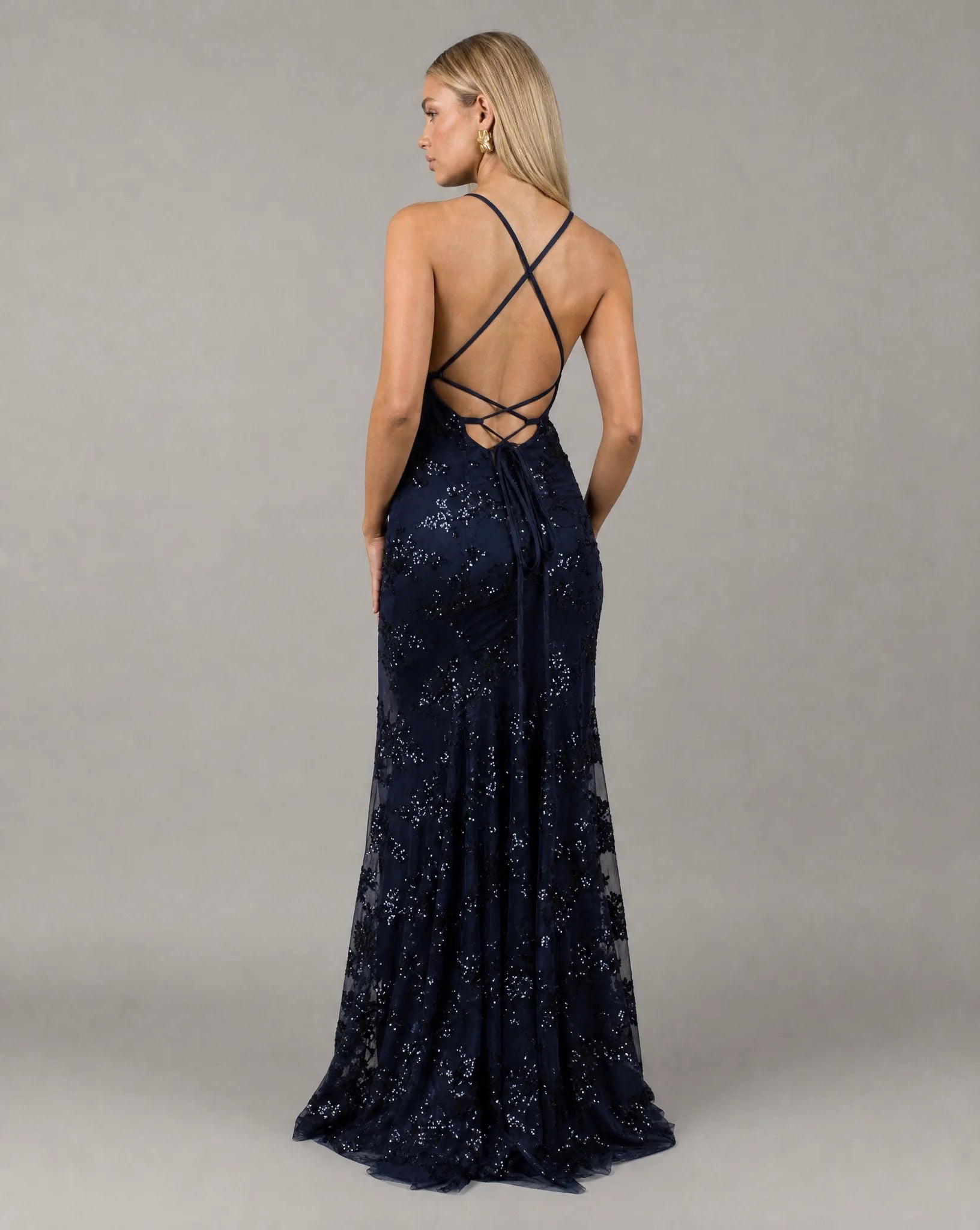 Dark blue sequin evening maxi dress back view with criss cross straps and fitted mermaid shape by ILYNORA