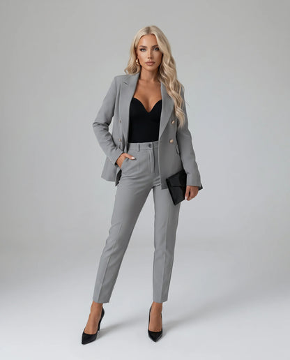 Grey tailored two piece pantsuit with double breasted blazer and sophisticated styling by ILYNORA