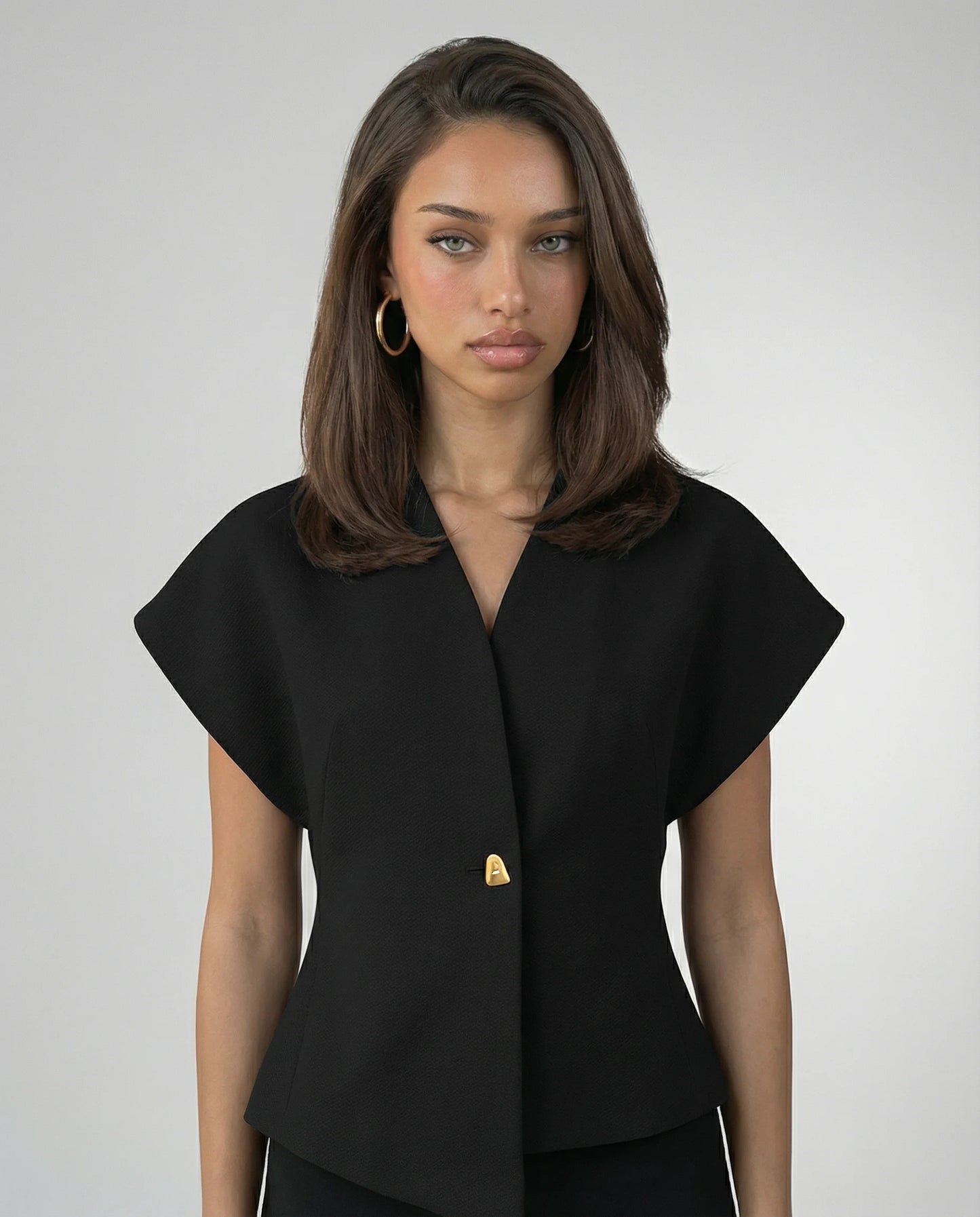 Black V-neck blouse for women by Ilynora, front view with clean tailored silhouette and button detail