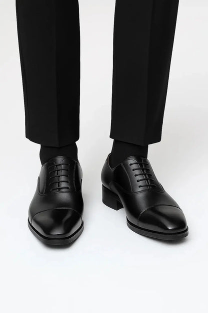 Front view of men's black leather derby dress shoes featuring genuine leather, cap toe design and elegant business styling by ILYNORA