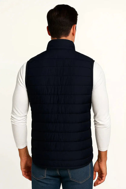 Back view of men's navy blue lightweight quilted puffer vest with quilted insulation and stand collar by ILYNORA